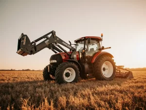 Custom tractor parts displayed alongside a tractor in a farmland setting at sunset, highlighting performance and fit.